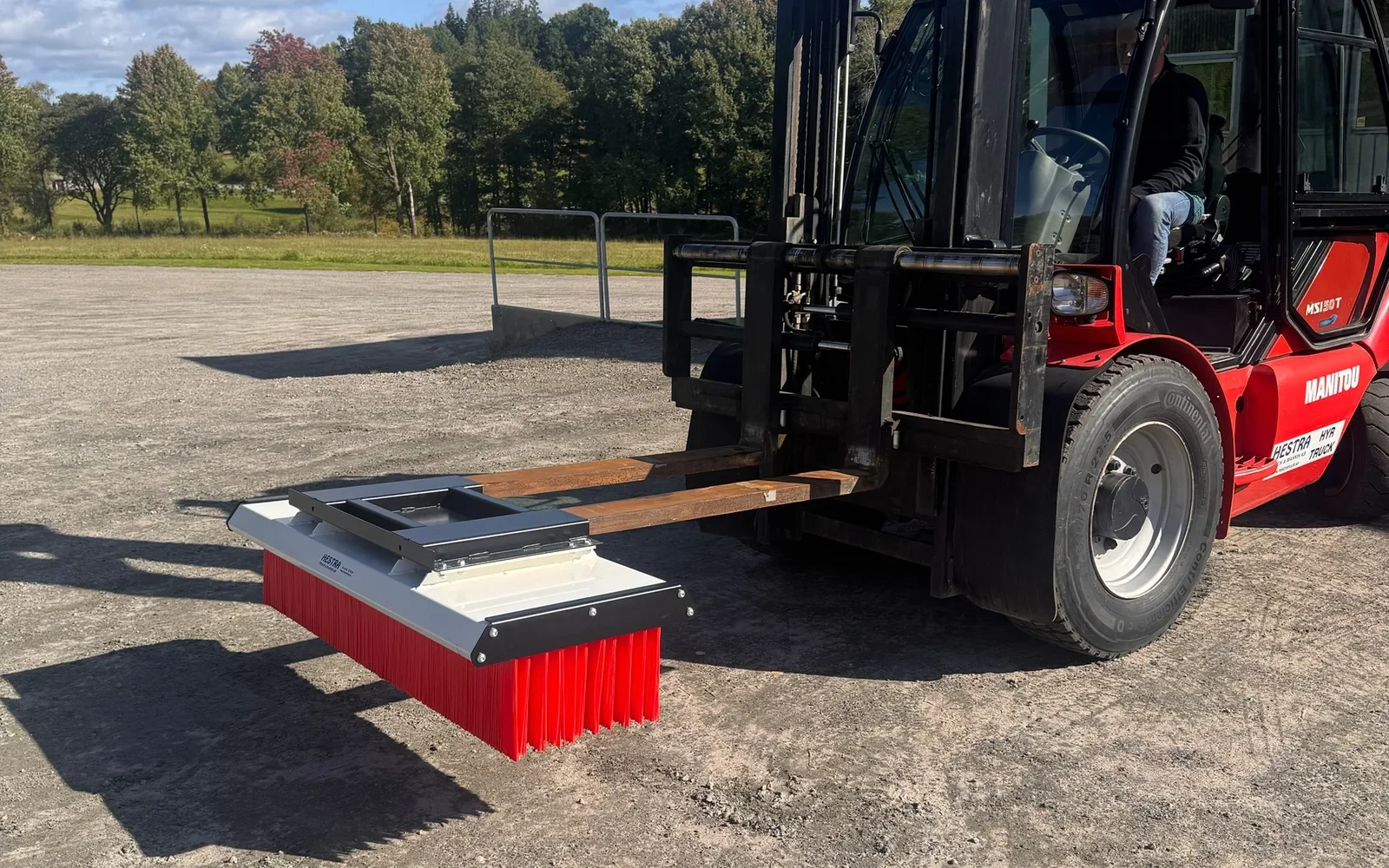 Sopborste monterad på gafflarna på en Manitou-truck hos Hestra Truck